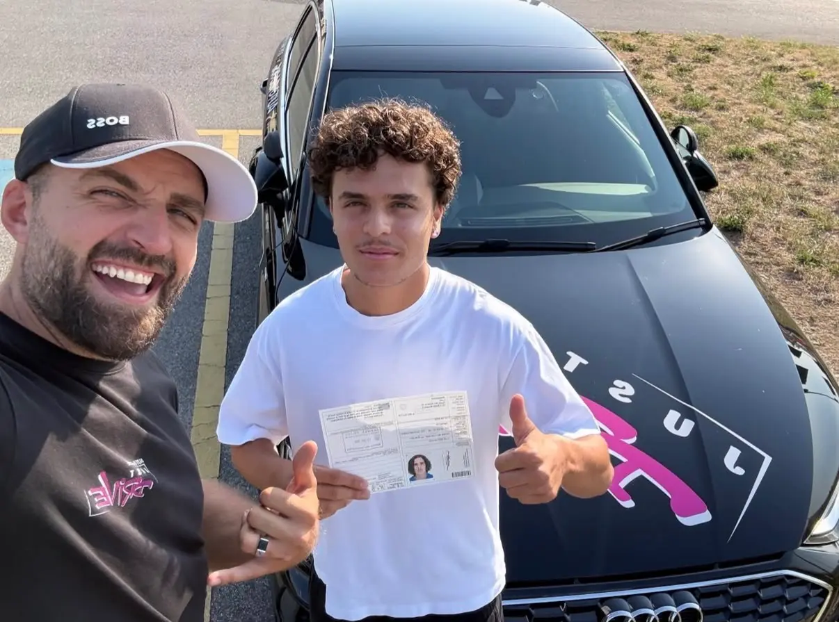 Mergim and his student posing beside the Just Drive car.