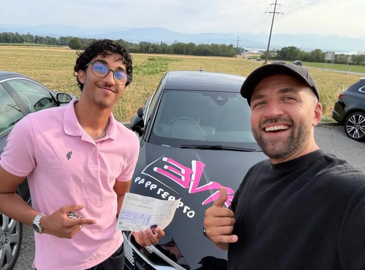Mergim with his student in a pink polo shirt after getting their driving licence.