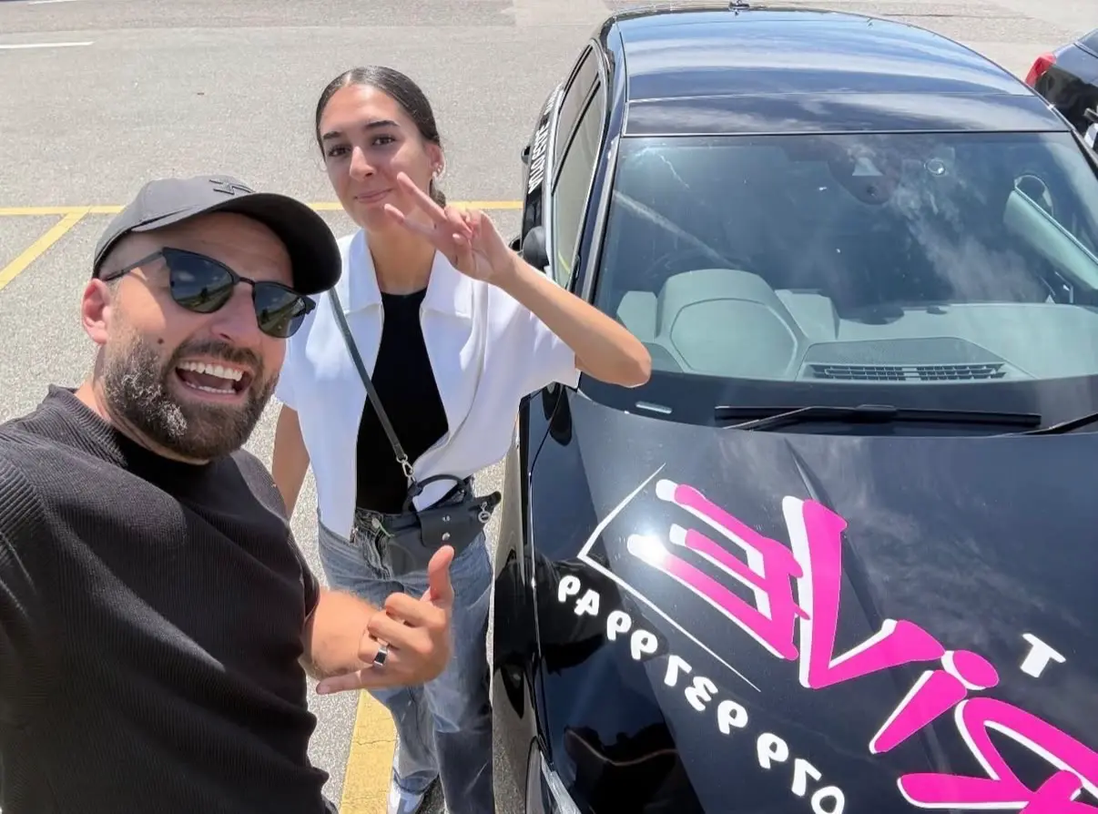 Celebrating a driving test pass with Mergim and a victory sign.